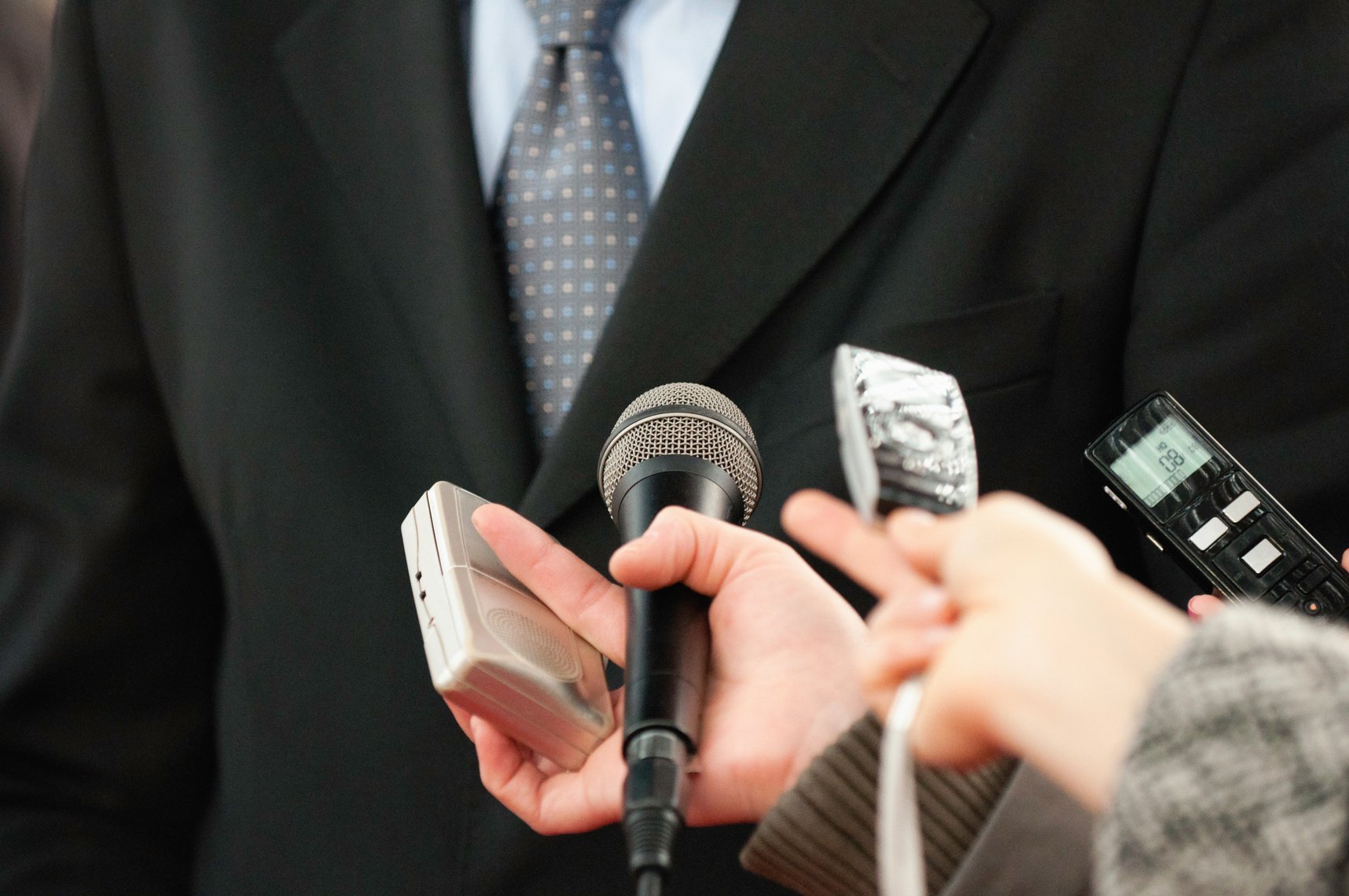 Cropped Image Of Journalists Holding Microphones By Politician